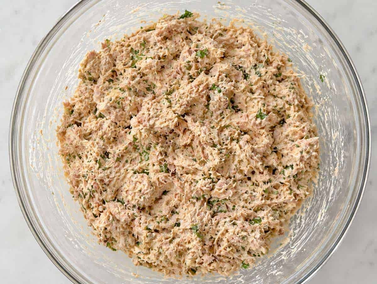 Step 2 Tuna mixture being mashed with yogurt, tahini, and herbs until creamy.