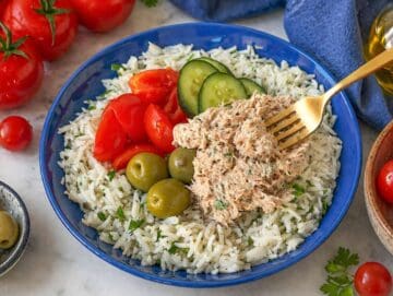 Step 3 Creamy tuna spooned over rice and vegetables with seeds and herbs on top.