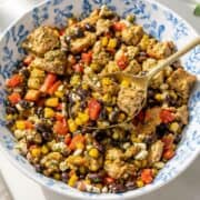 Colorful chicken black bean salad in a ceramic bowl in soft natural window light.
