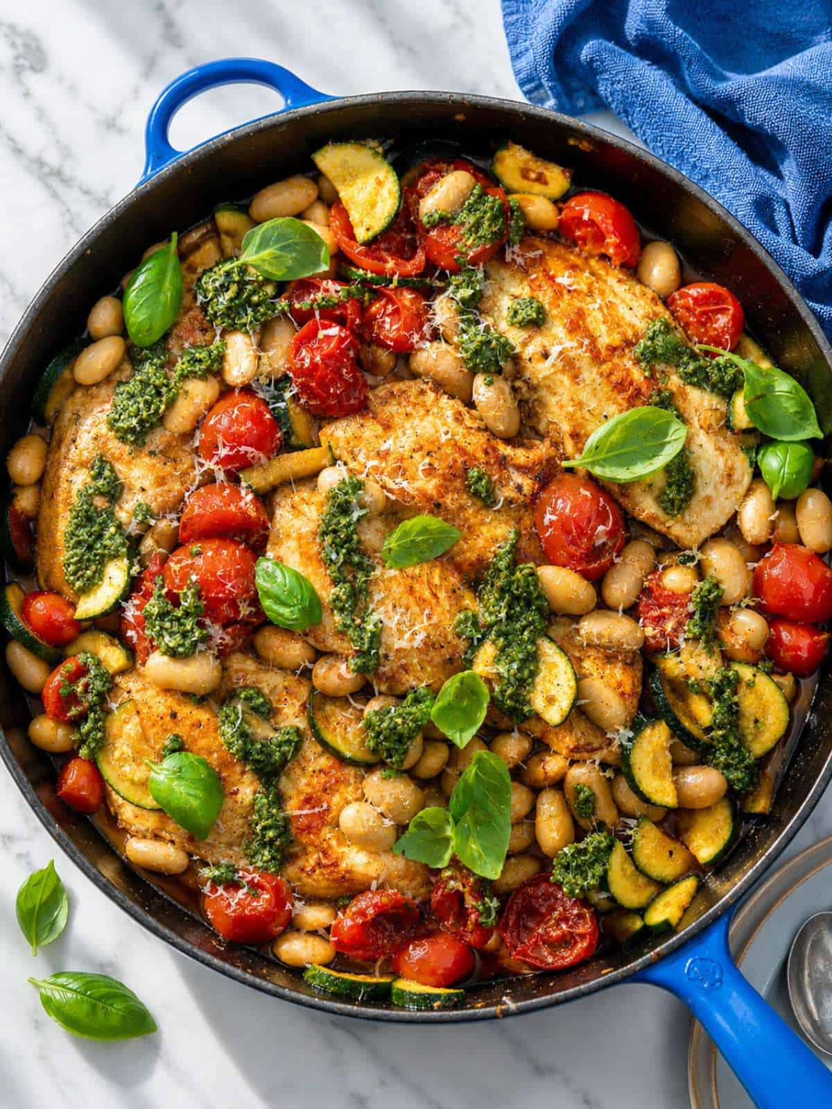 Pesto chicken skillet with butter beans, zucchini, and blistered cherry tomatoes.