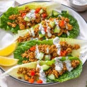 Platter of Turkey Lettuce Wraps with colorful toppings and creamy yogurt sauce in lettuce wraps.