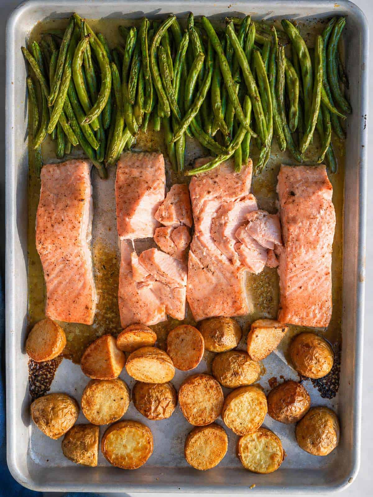 Sheet Pan Salmon With Vegetables served with roasted potatoes and green beans.