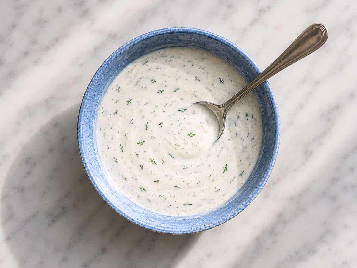 Step 1 Greek yogurt sauce with dill, garlic, lemon, and olive oil whisked in a small bowl.