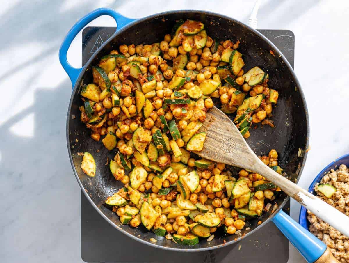 Step 2 Zucchini, red onion, and chickpeas cooking in large skillet with olive oil.