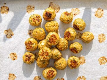 Step 3 Baked Greek turkey meatballs golden on top with herbs and feta on sheet pan.