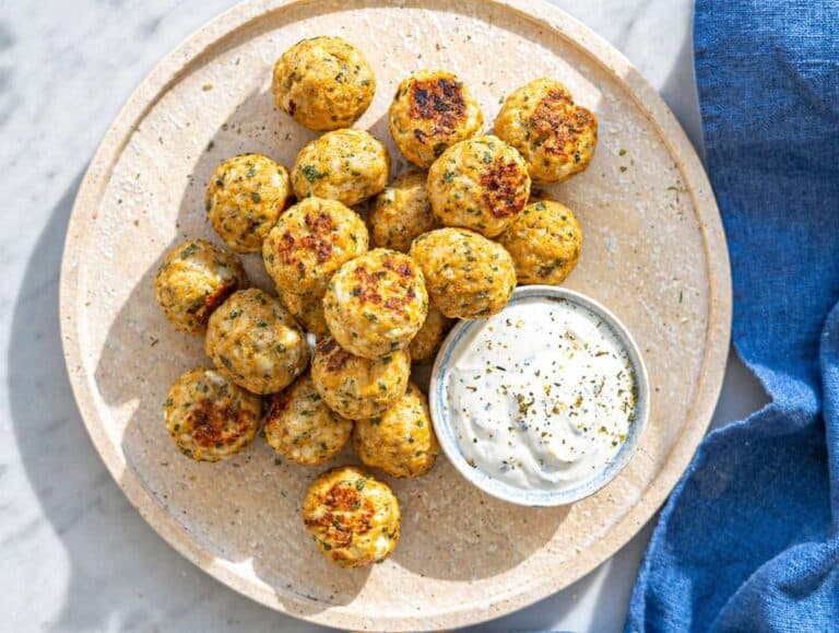 Step 4 Greek turkey meatballs served with creamy tzatziki on ceramic plate in natural light.