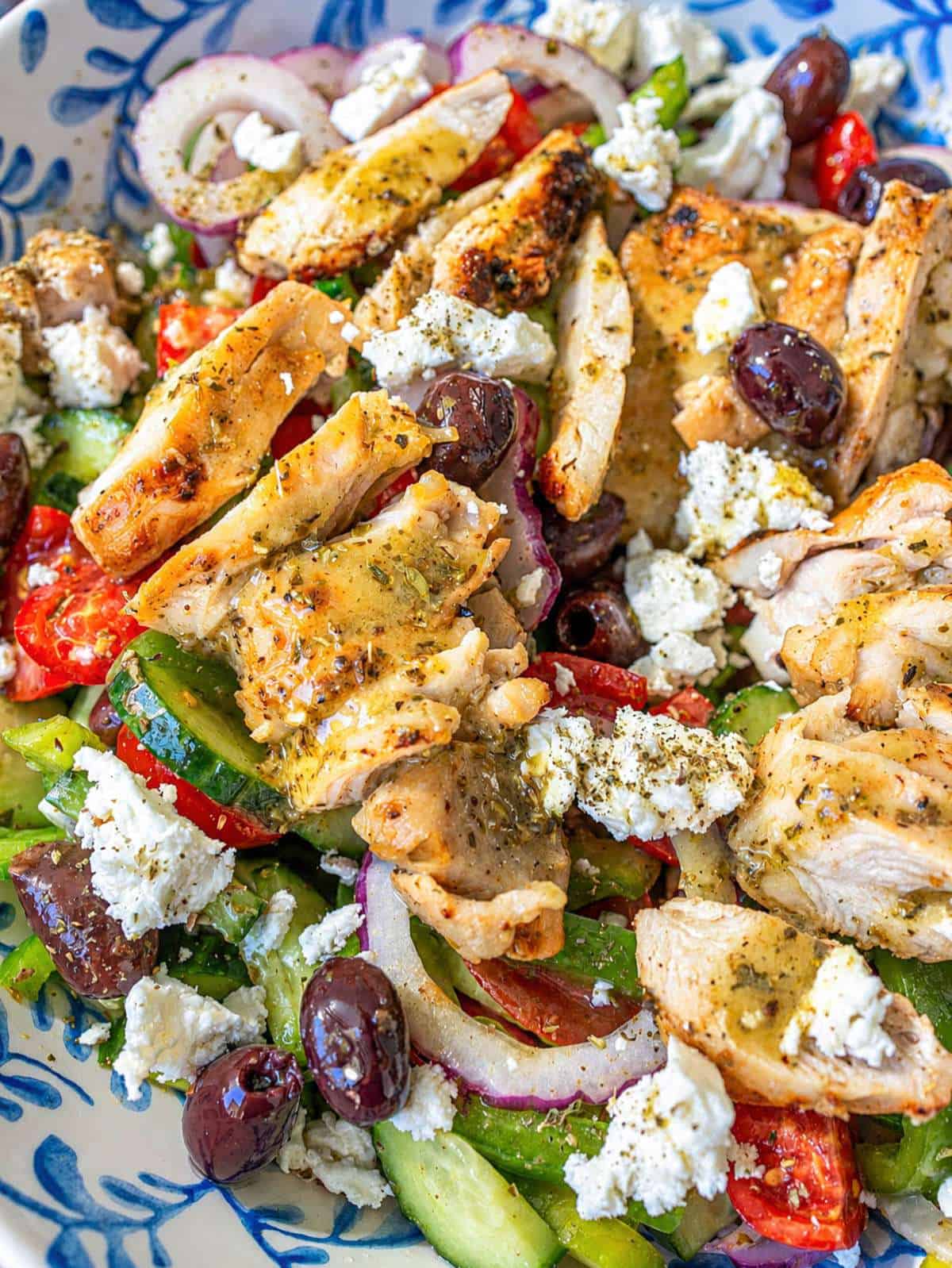 Close-up of juicy grilled chicken over crisp Mediterranean vegetables.