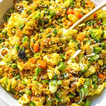 Easy egg fried rice served in a bowl with green onions and vegetables.