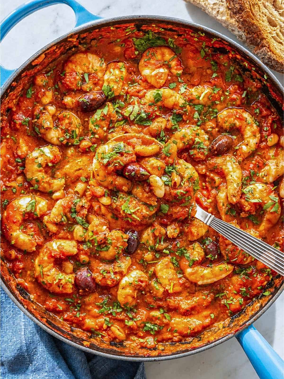 Shrimp puttanesca skillet with cannellini beans and olives.