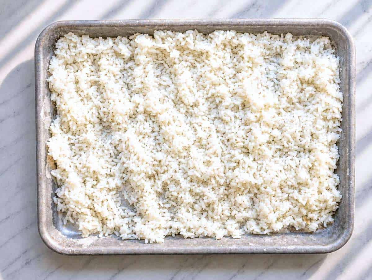 Step 1 Cooked white rice cooling on marble platter.