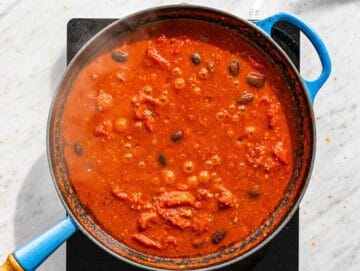Step 1 Shrimp puttanesca sauce simmering with olives.