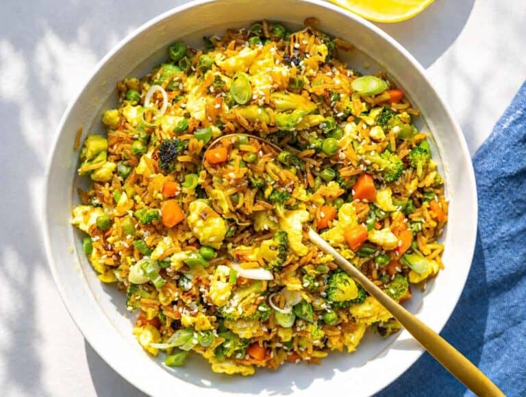 Step 4 Finished egg fried rice served warm with sesame seeds and a golden spoon.
