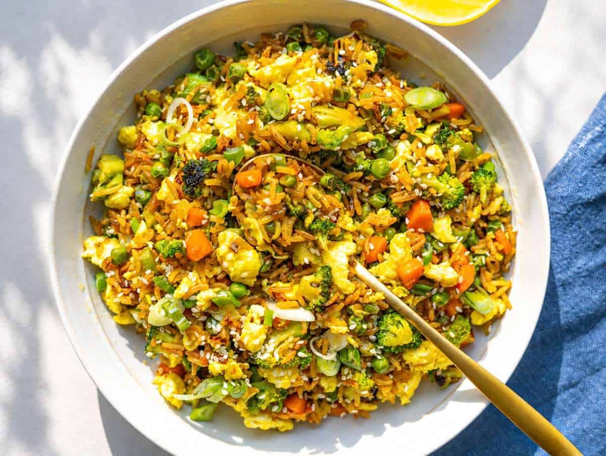 Step 4 Finished egg fried rice served warm with sesame seeds and a golden spoon.