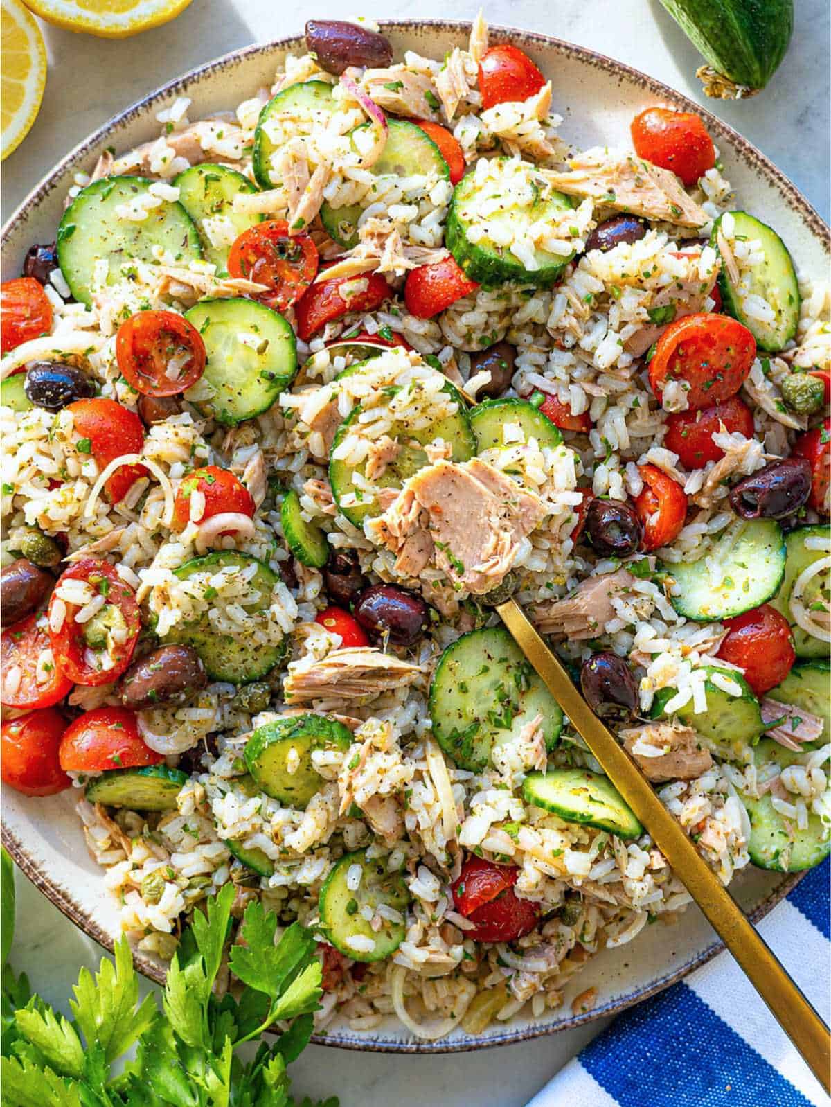 Tuna rice salad with tomatoes, cucumber and olives.